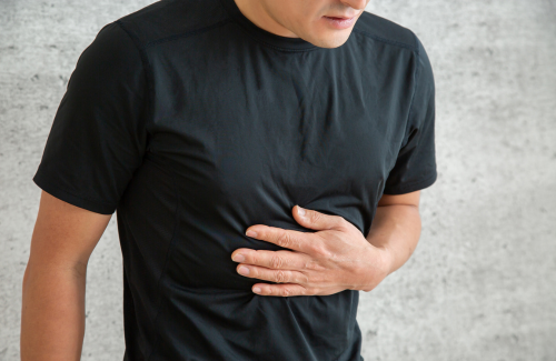 みぞおちに気持ち悪さを感じている男性