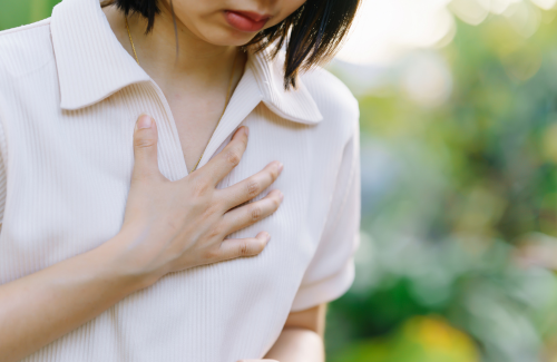 胸を押さえる女性