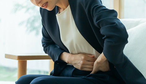 お腹を押さえる女性