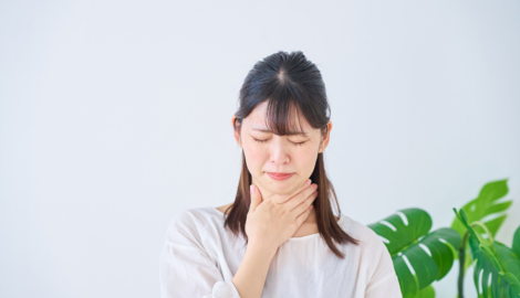 喉を押さえる女性