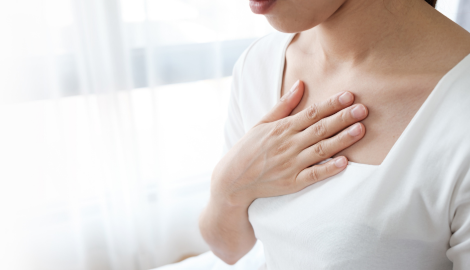 胸を押さえる女性