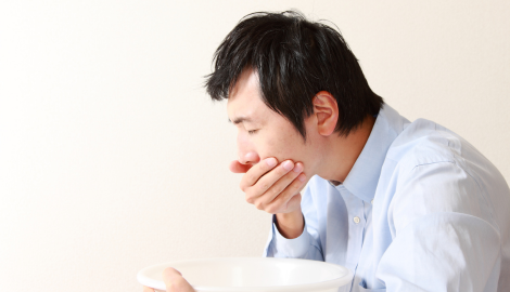 吐き気でつらそうな男性