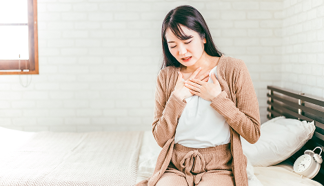 胸を押さえる女性