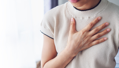 胸を押さえる女性