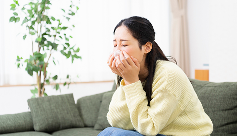 鼻を抑える女性