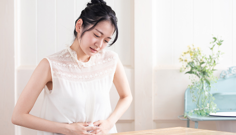 胃を押さえる女性