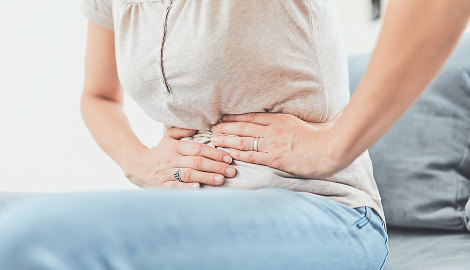 お腹を押さえる女性