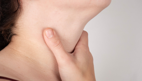 喉を押さえる女性