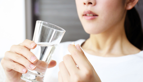 喉を押さえる女性